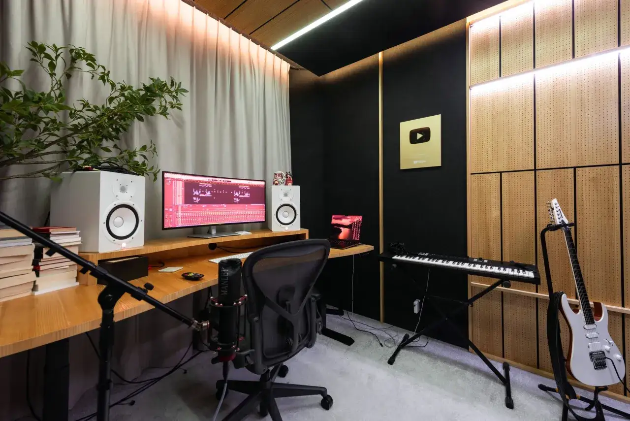 W tym quebonafide studiach, gdzie tworzy się muzykę, widać komputer z programem do produkcji, głośniki, mikrofon, keyboard i gitarę.