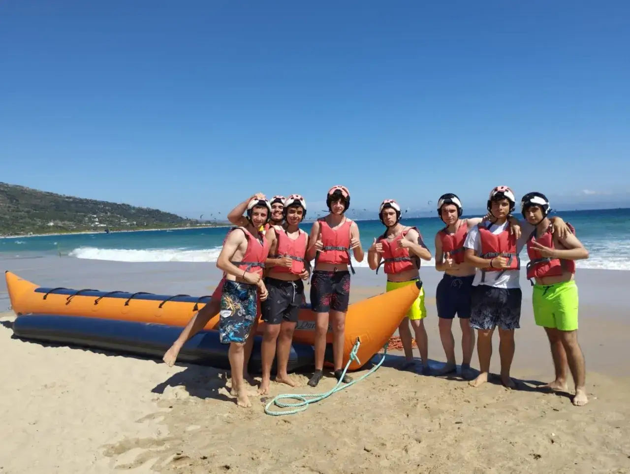 Grupo de adolescentes listos para la banana boat en la playa. ¡Un plan perfecto donde viajar con adolescentes en España!