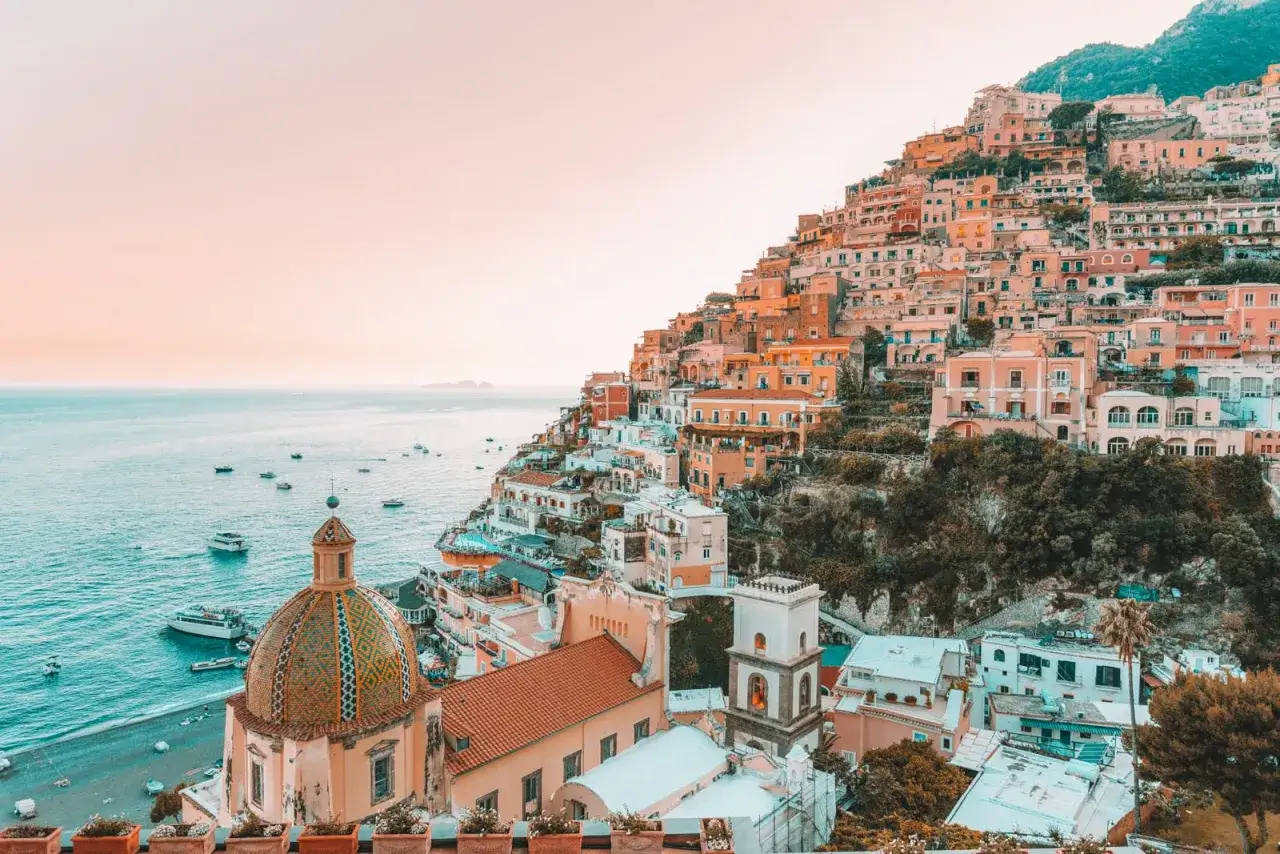 F&auml;rgstarka hus kl&auml;ttrar uppf&ouml;r en brant sluttning vid havet, en vy som utstr&aring;lar mysiga resm&aring;l i Italien.