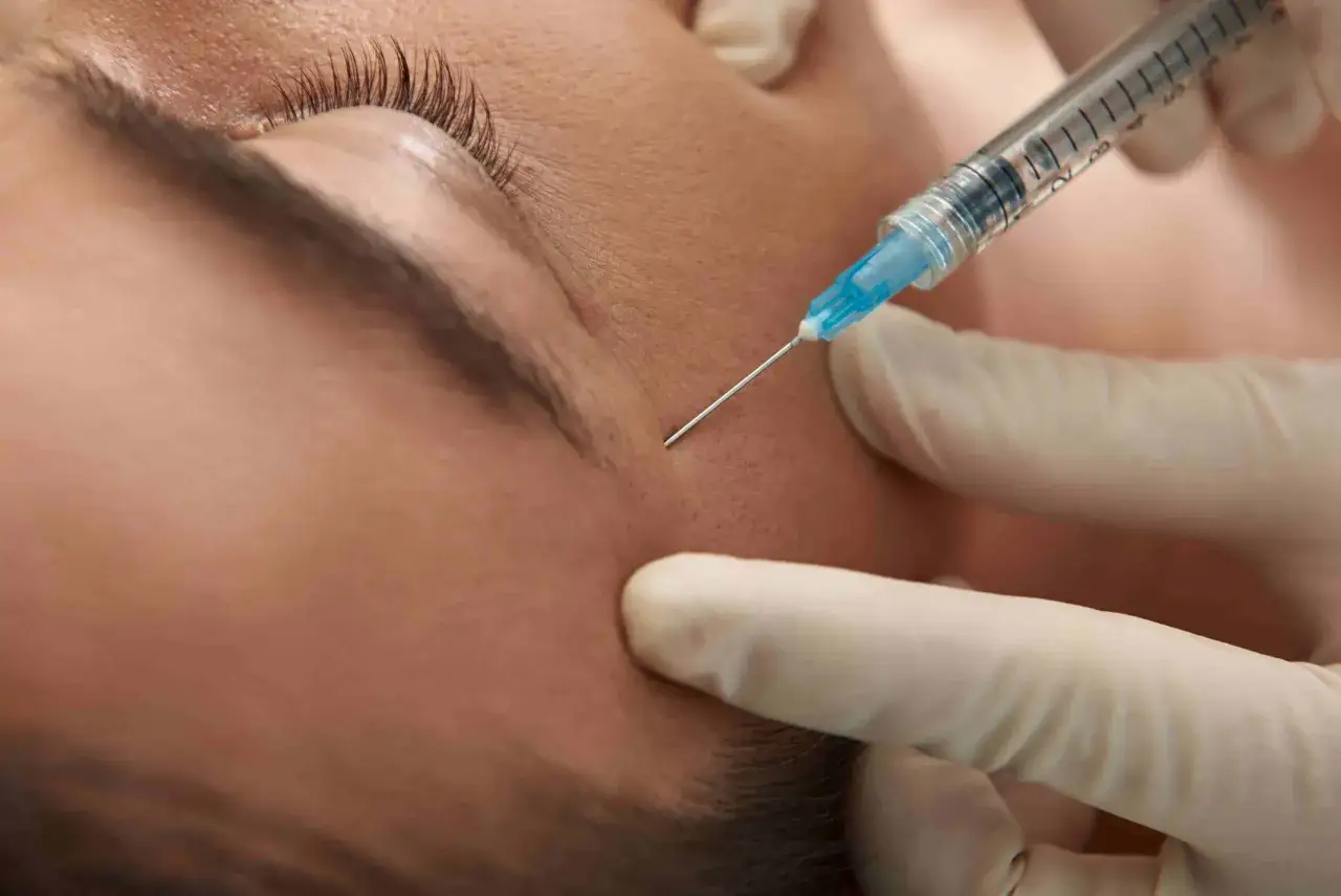 Zabieg medycyny estetycznej: precyzyjny injection w okolicę oka, wykonywany w rękawiczkach.