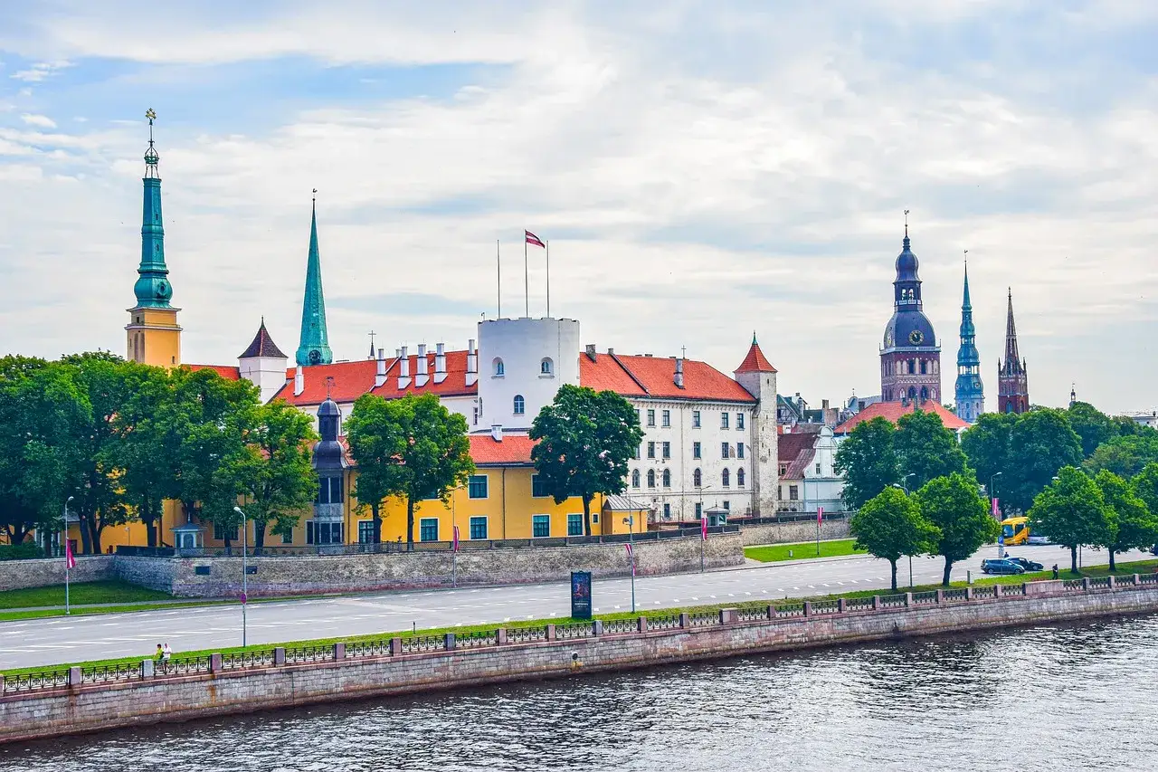Rzeka Dźwina i panorama Rygi z wieżami kościołów, zamkiem i zielenią. Warto zobaczyć w Rydze te zabytki!