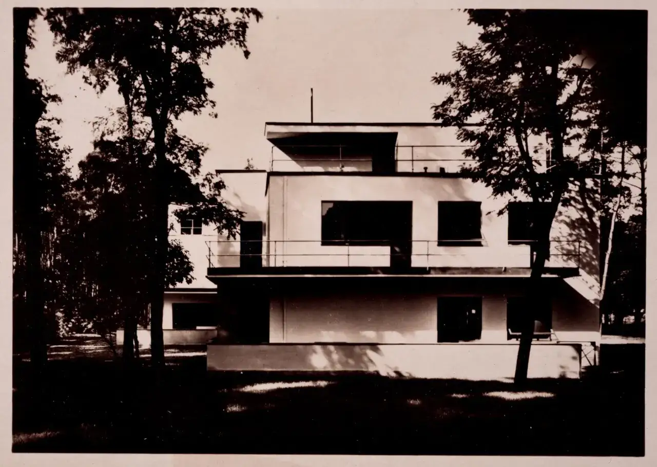 Kubistische Architektur der 1920er Jahre: Ein helles, modernes Haus mit klaren Linien und gro&szlig;en Fenstern, umgeben von B&auml;umen.
