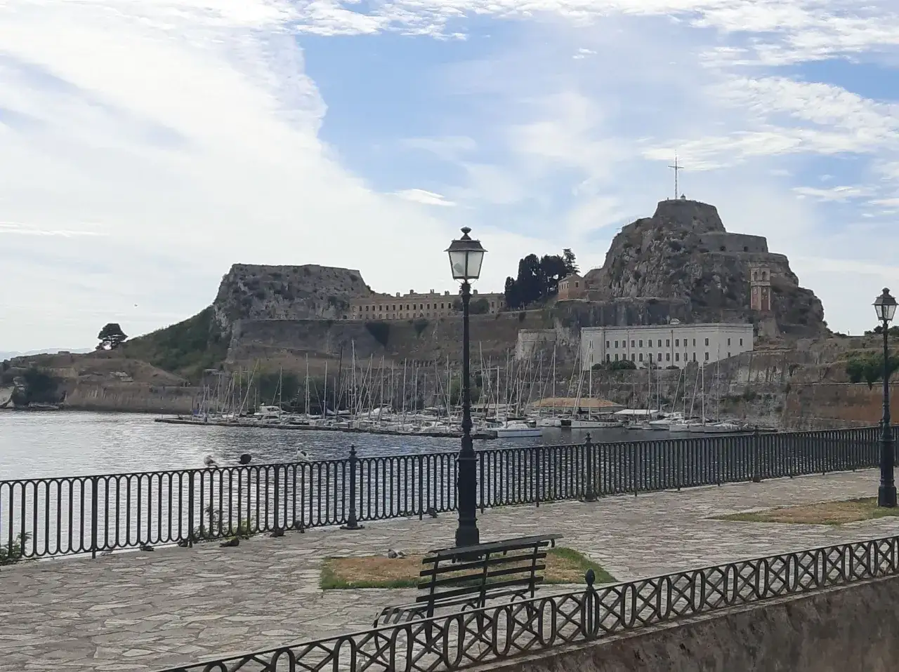 Widok na Stare Miasto i port w Korfu. Warto zobaczyć fortyfikacje i zatokę pełną jacht&oacute;w.
