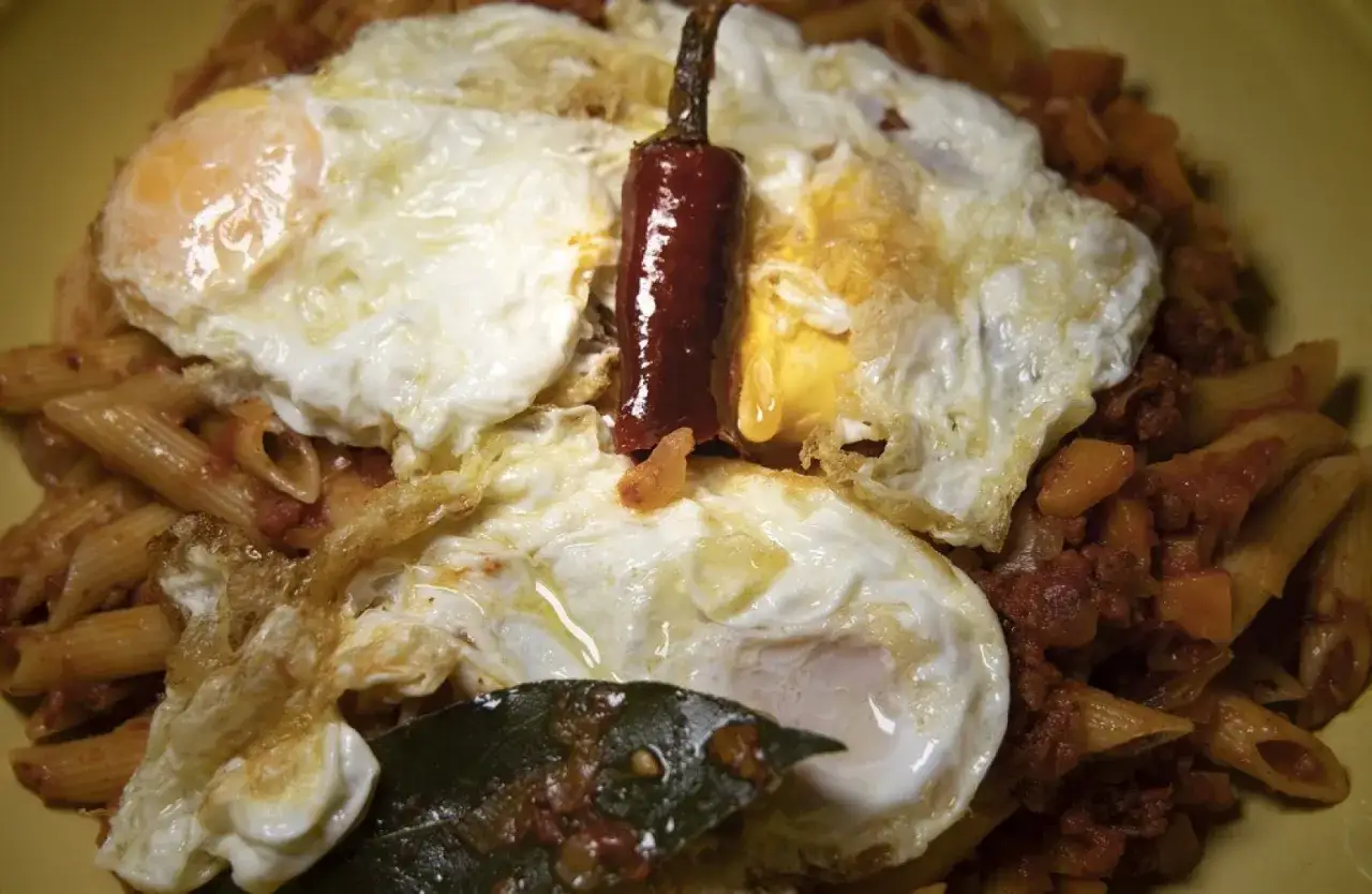 Macarrones con chorizo, coronados con huevos fritos y un chile seco. Un plato contundente y sabroso.