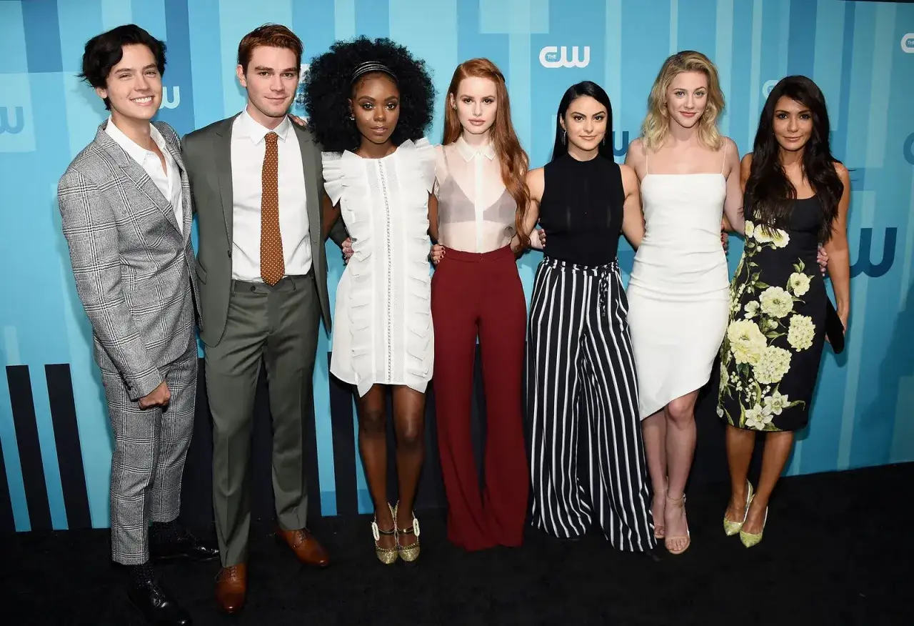 Uśmiechnięta Riverdale obsada pozuje do zdjęcia.