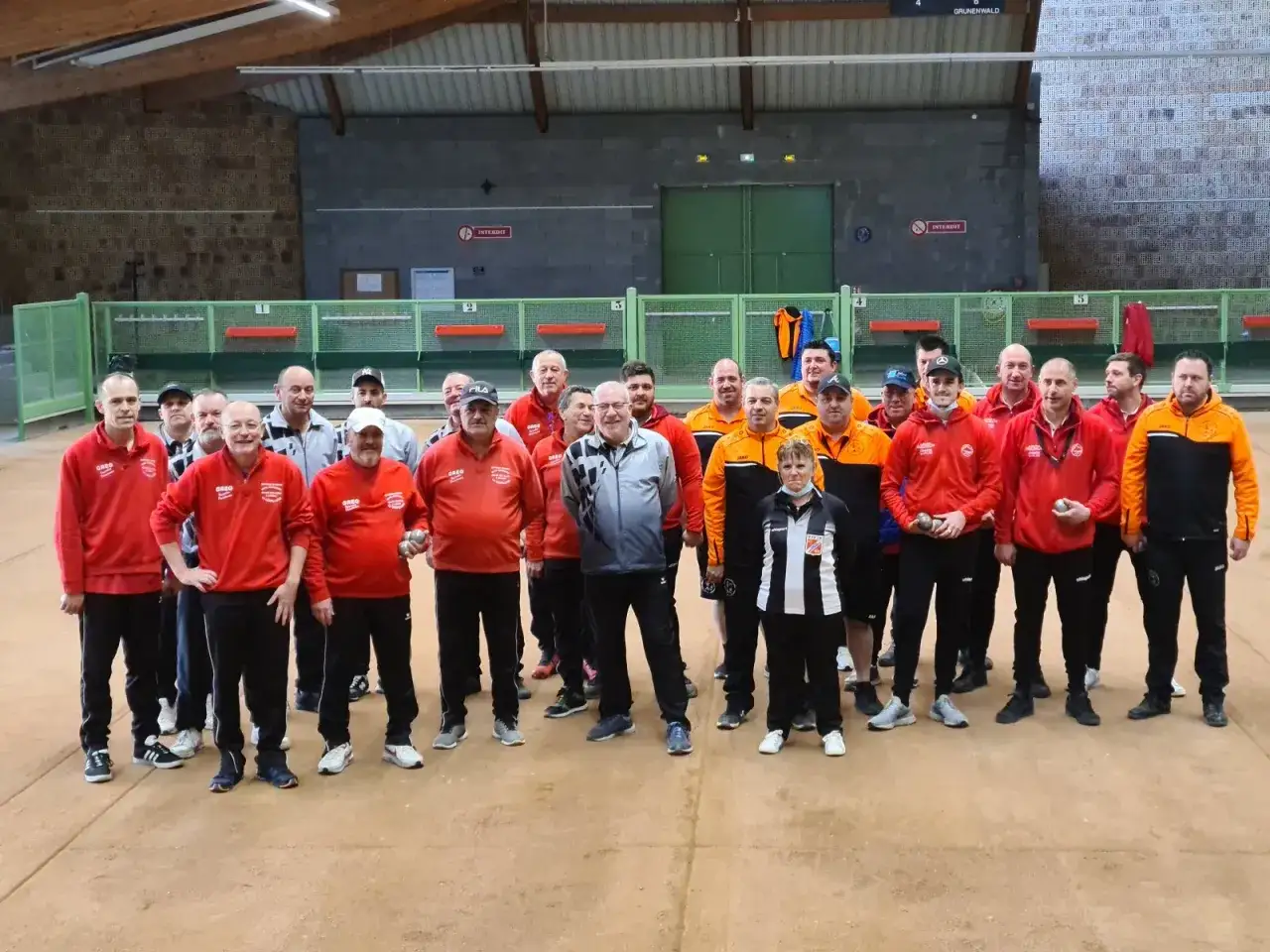 Un groupe de joueurs de pétanque pose pour une photo. La pétanque est-il un sport ? Ces athlètes en tenue semblent le confirmer.