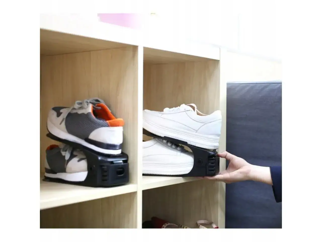 Praktyczny organizer na buty, który pozwala na podwójne ułożenie obuwia na półce. Widać buty sportowe i białe sneakersy.
