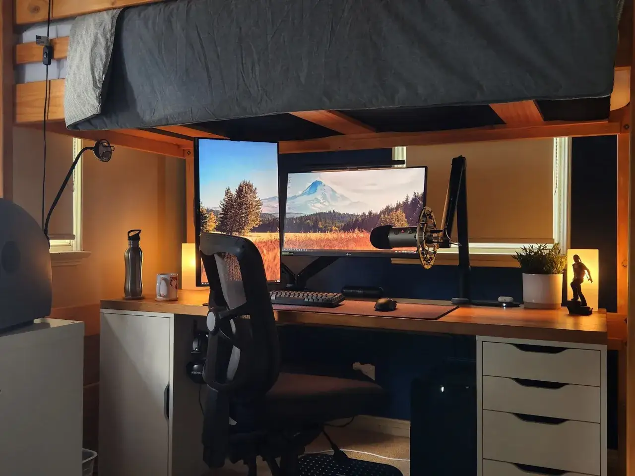 Habitaciones pequeñas con literas, un escritorio con monitores, micrófono y silla gamer.