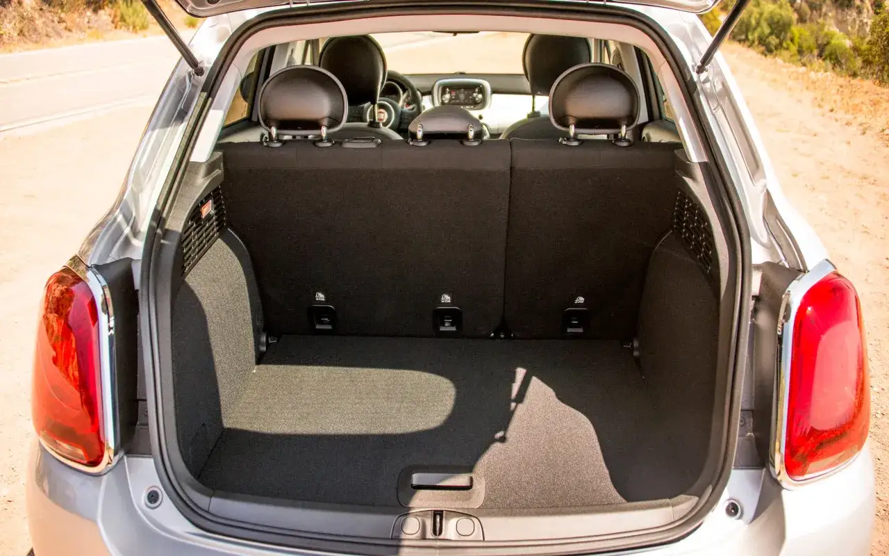 Le coffre ouvert d'une Fiat 500X, prêt à accueillir vos bagages pour une escapade.