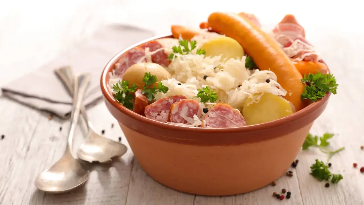 Un plat généreux de choucroute garnie, symbole de la gastronomie alsace, avec saucisses, pommes de terre et lard.