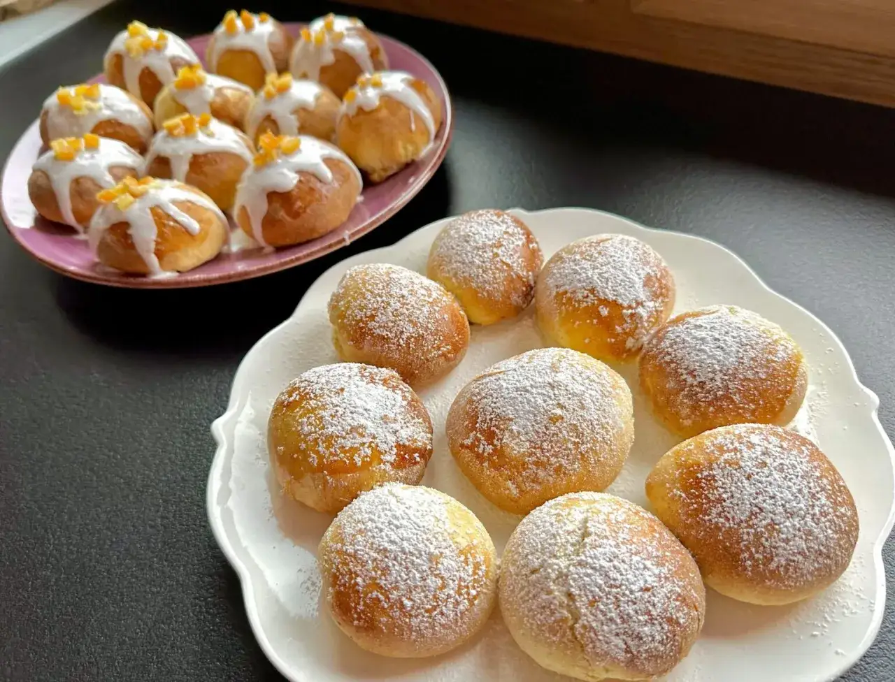 Szybkie pączki z piekarnika, jedne posypane cukrem pudrem, drugie lukrem i skórką pomarańczową.