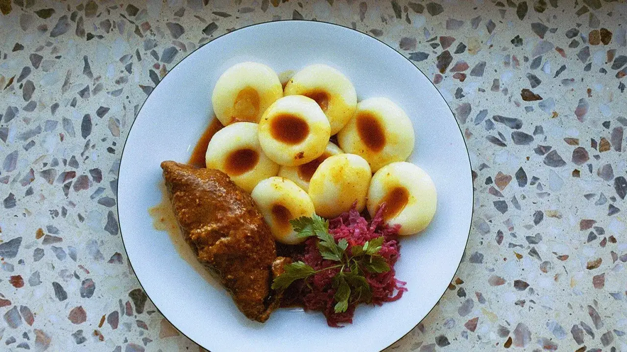 Talerz z kluskami śląskimi, roladą i czerwoną kapustą. Zastanawiasz się, ile kcal ma kluska śląska?