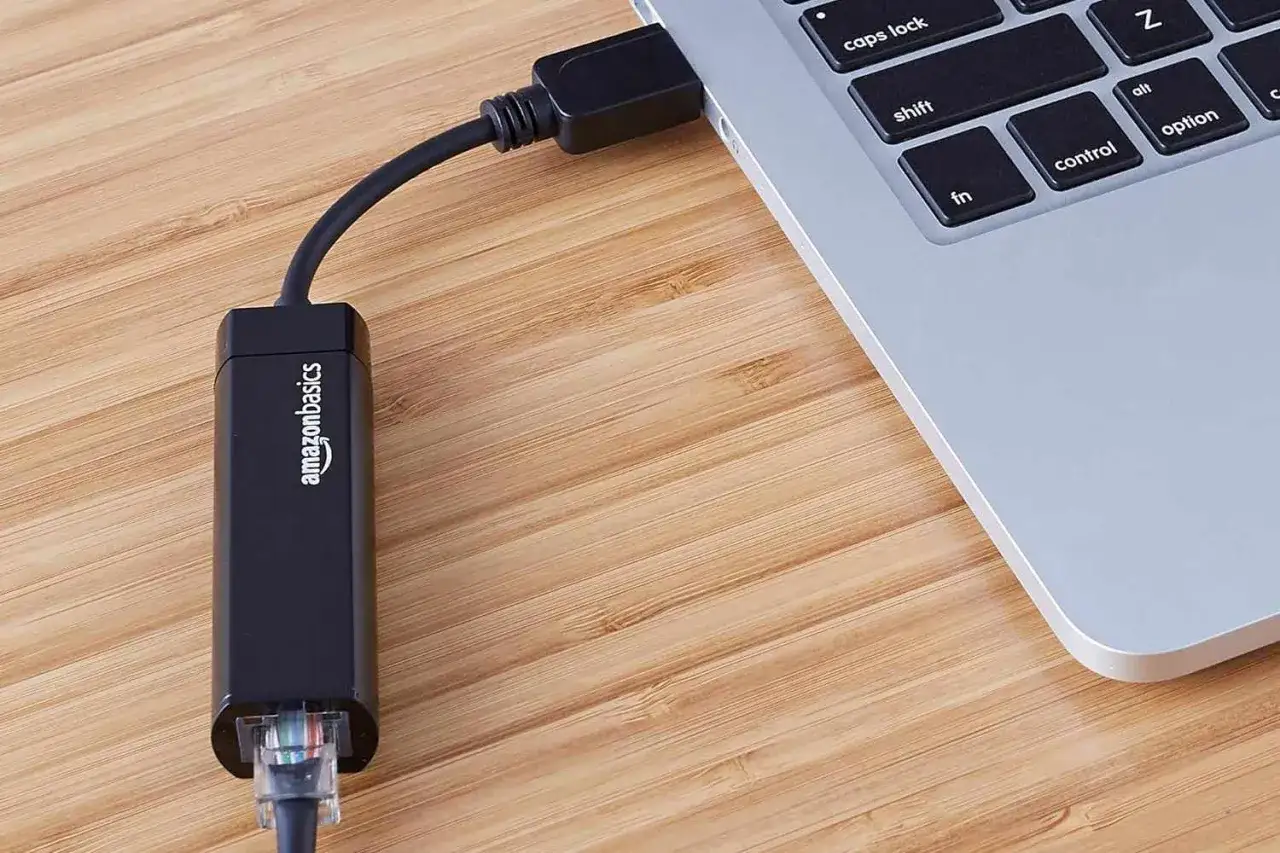 Adapter Amazon Basics podłączony do laptopa, pokazujący, jak podłączyć kabel sieciowy do laptopa.