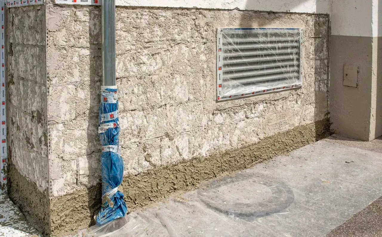 Bauarbeiten am Haus: Die untere Wand wird für die gartenmauer abdichten vorbereitet. Ein Rohr ist provisorisch geschützt.