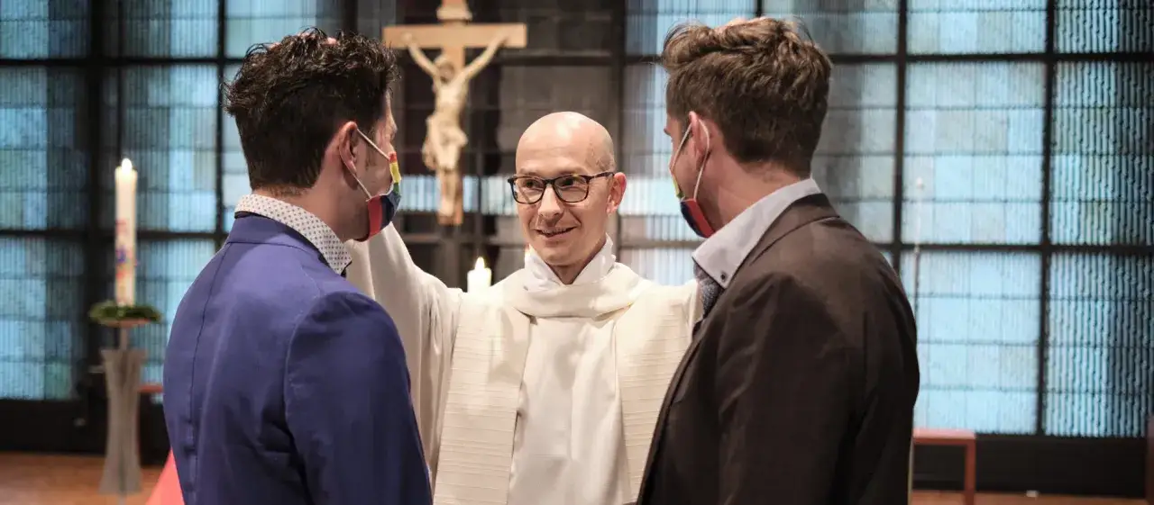 Ein Geistlicher segnet ein Paar in der Kirche. Die gleichgeschlechtliche Ehe wird hier gefeiert.