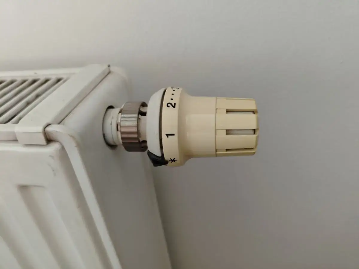 Termostat na grzejniku ustawiony na niską temperaturę. Grzejnik słabo grzeje, mimo że pokrętło jest na