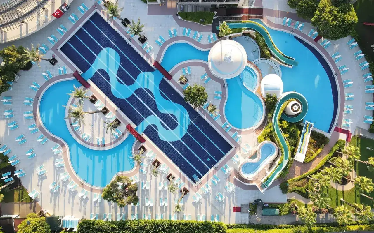 Luftaufnahme des Limak Atlantis De Luxe Hotel & Resort mit Pools, Wasserrutschen und Liegest&uuml;hlen.