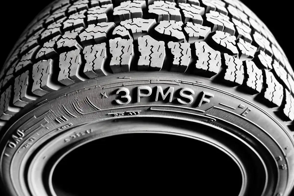 Gros plan sur un pneu d'hiver, le symbole 3PMSF indiquant sa performance sur neige.