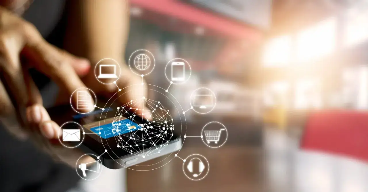 Mano usando smartphone con iconos de marketing automation: email, carrito, web, etc.