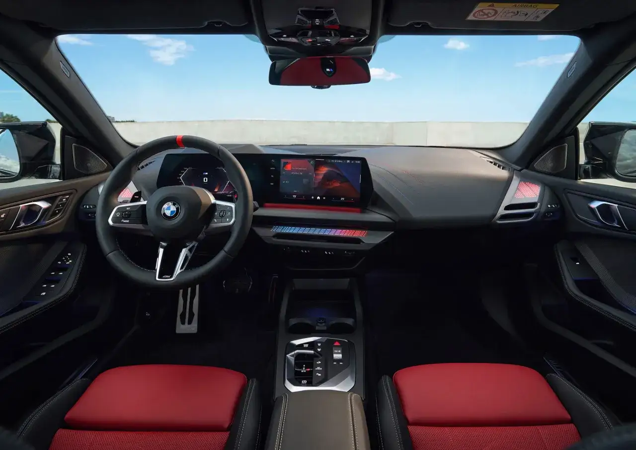 Wnętrze BMW 2 Gran Coupe z czerwonymi akcentami i nowoczesnym panelem multimedialnym.
