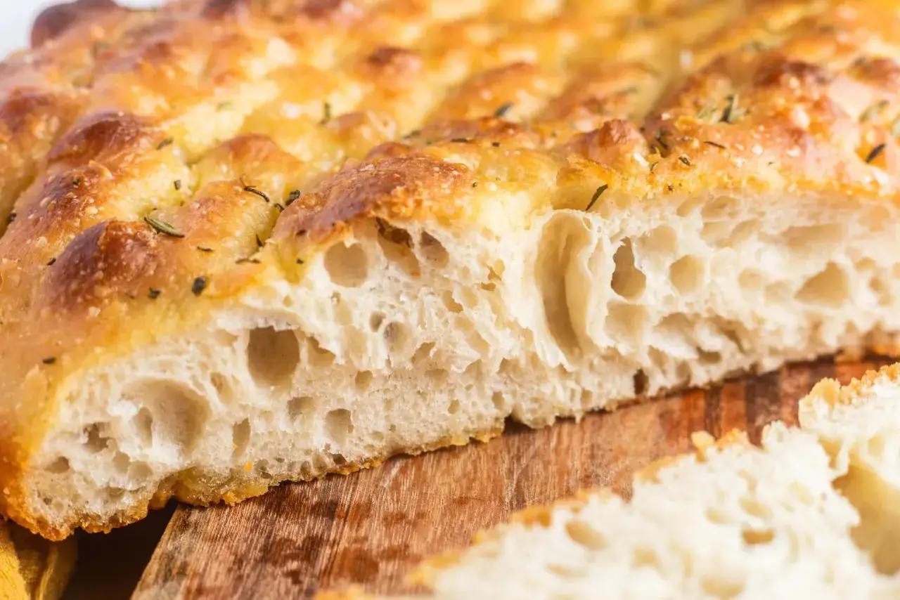 Puszysta, złocista focaccia z rozmarynem i solą morską, idealna do oryginalnego włoskiego przepisu.