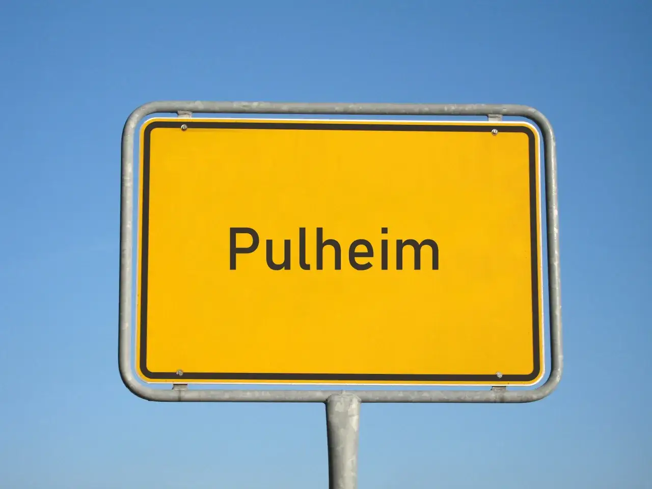 Ortsschild Pulheim vor blauem Himmel. Hier finden Sie Informationen zum Mietspiegel Pulheim.