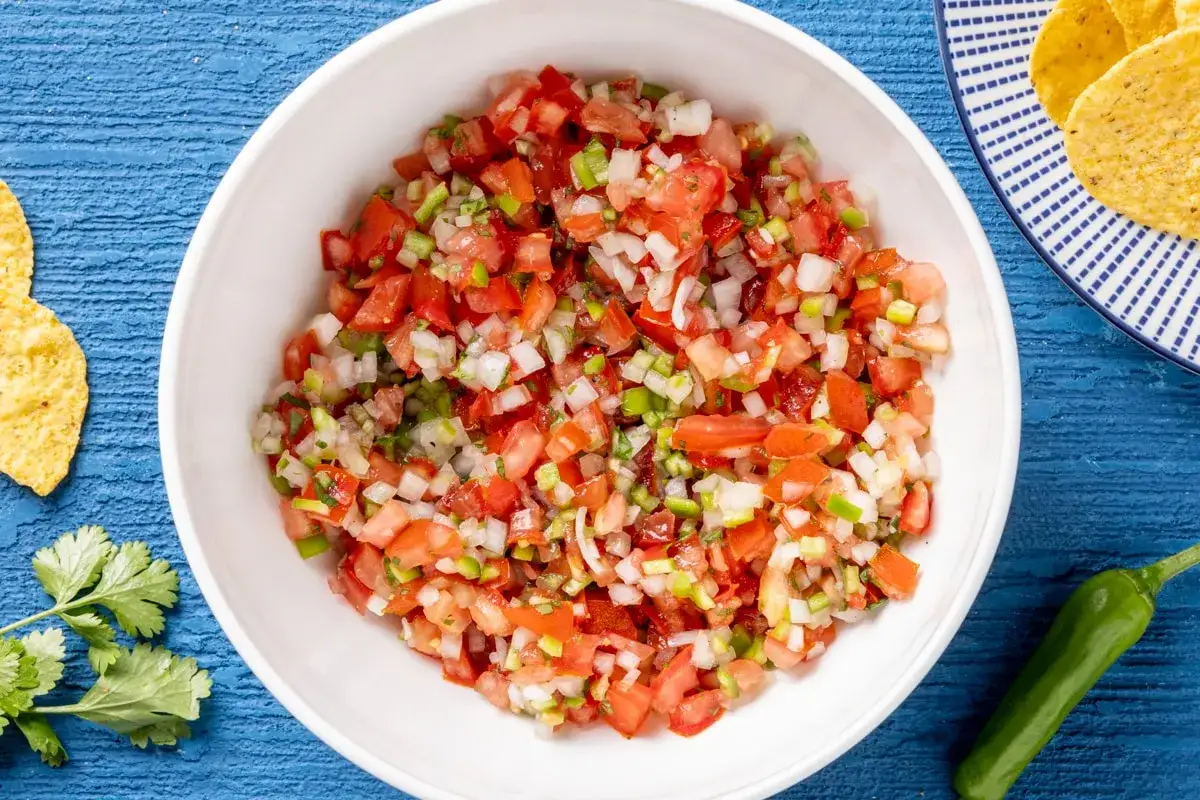 Pico de gallo ricetta: pomodori, cipolla, peperoncino e coriandolo freschi, pronti per essere gustati con nachos.