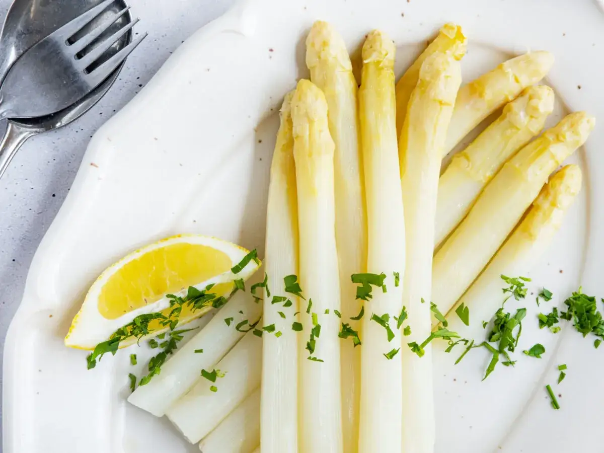 Frischer weißer Spargel mit Zitrone und Petersilie. Die ideale Kochzeit für Spargel ist entscheidend für den perfekten Genuss.