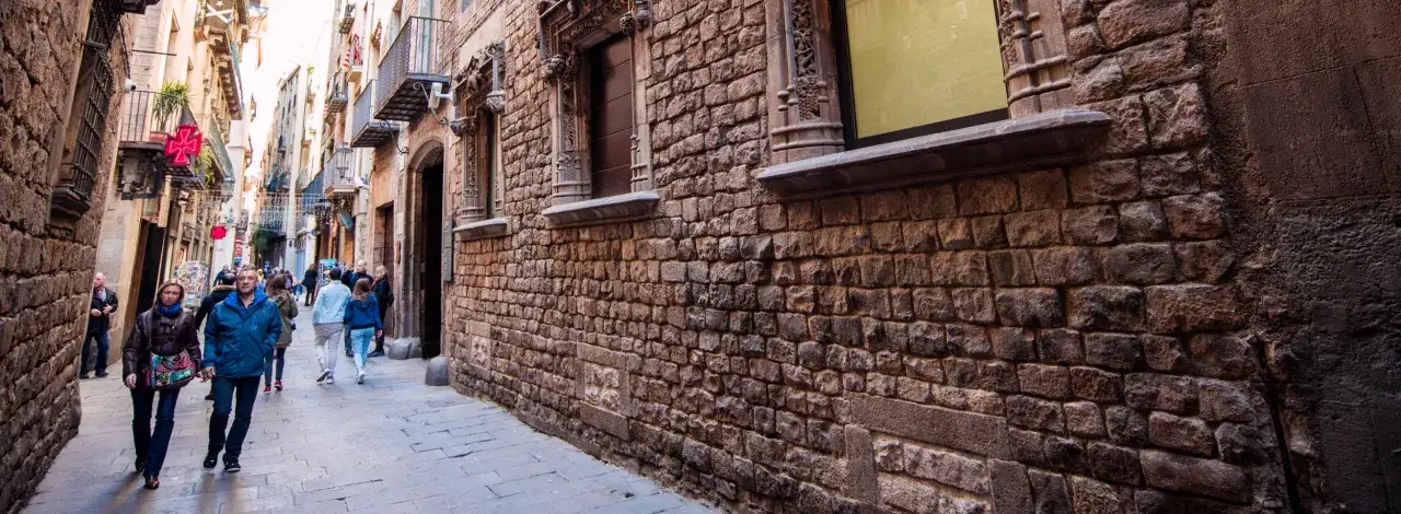 Spacerem po wąskich uliczkach starego miasta Barcelona, wśród kamiennych murów i zabytkowych budynków.