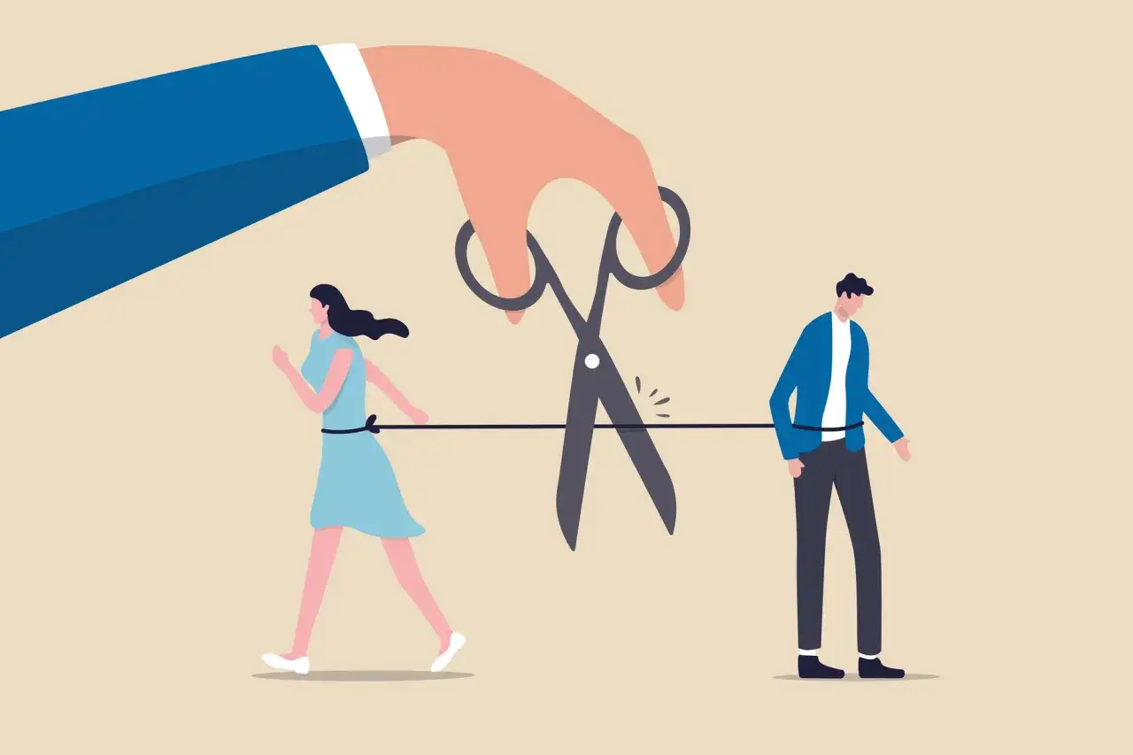 Una mano gigante taglia il legame tra una coppia, simboleggiando l'ansia da separazione dal partner e la paura di essere lasciati soli.