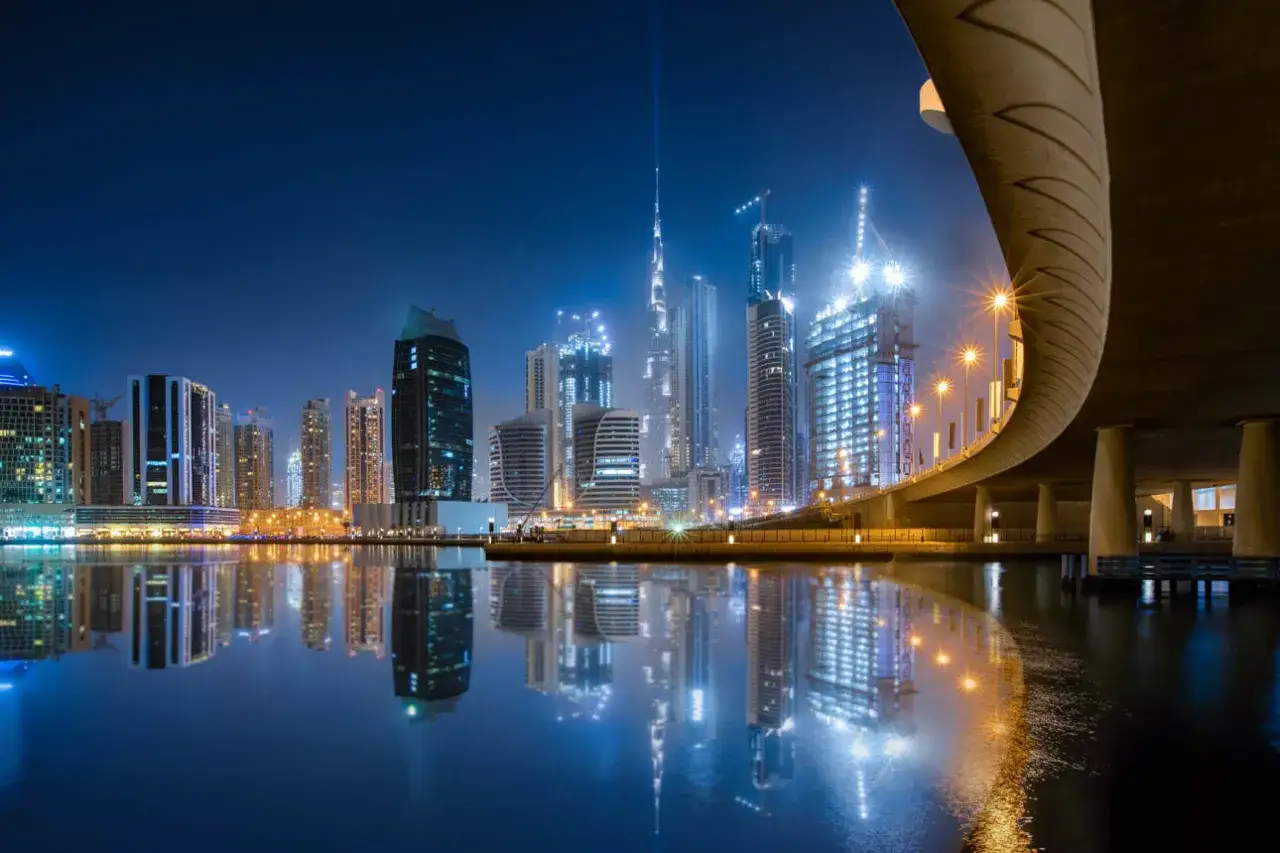 Dubaj nocą, lśniące wieżowce i most. Tu lottomilionerzy inwestują wygrane w złoto i nieruchomości.