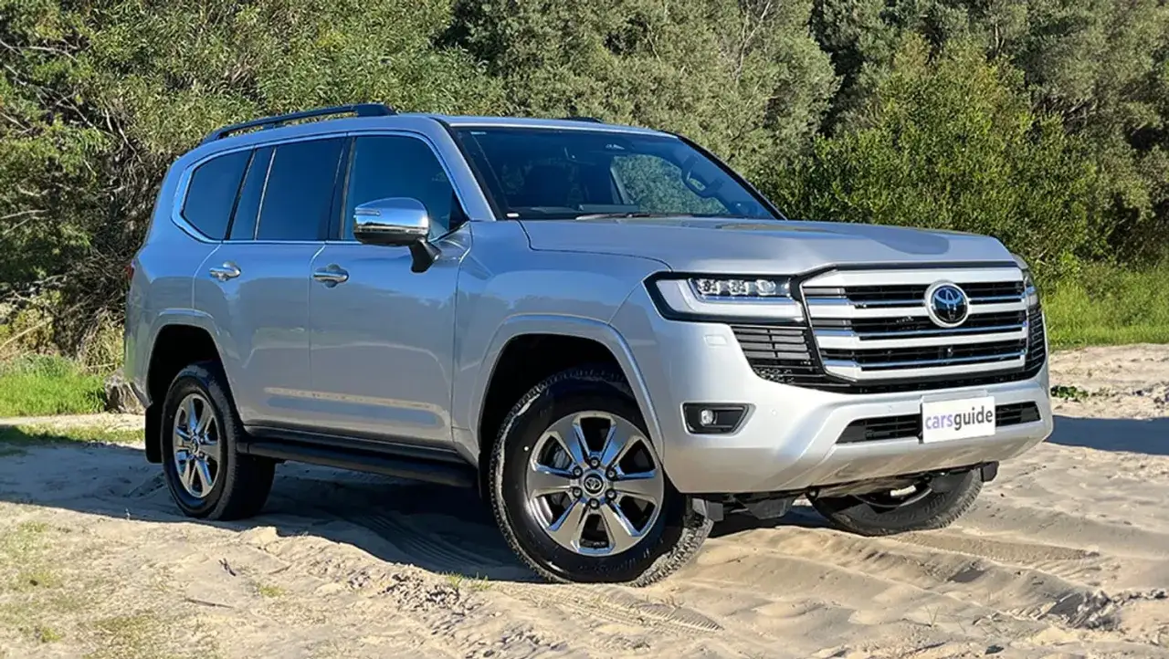 Srebrny Land Cruiser 300 na piaszczystym podłożu, gotowy na przygodę.
