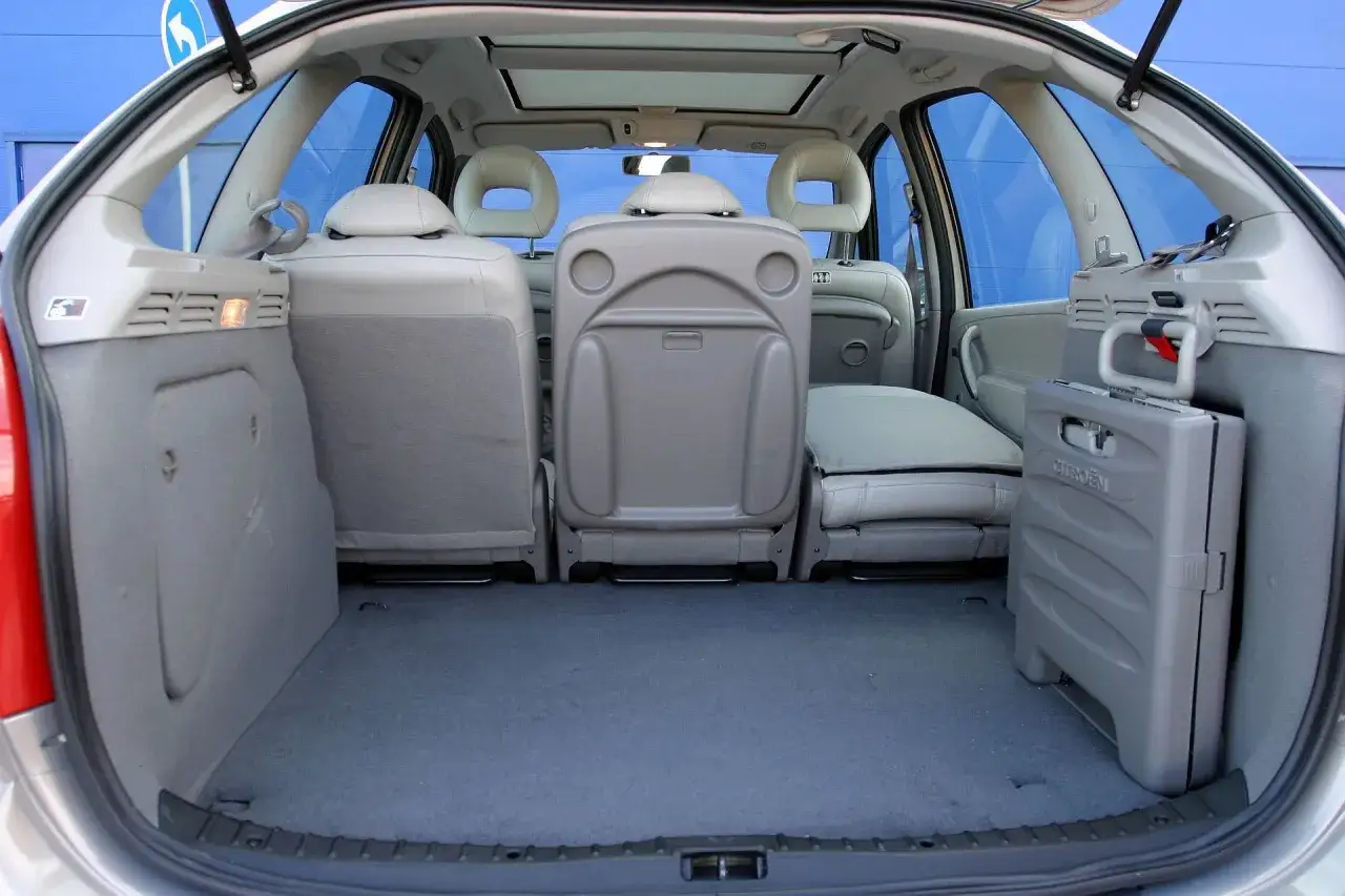 Wnętrze Citroëna Xsara Picasso z rozłożonymi siedzeniami i schowkiem.