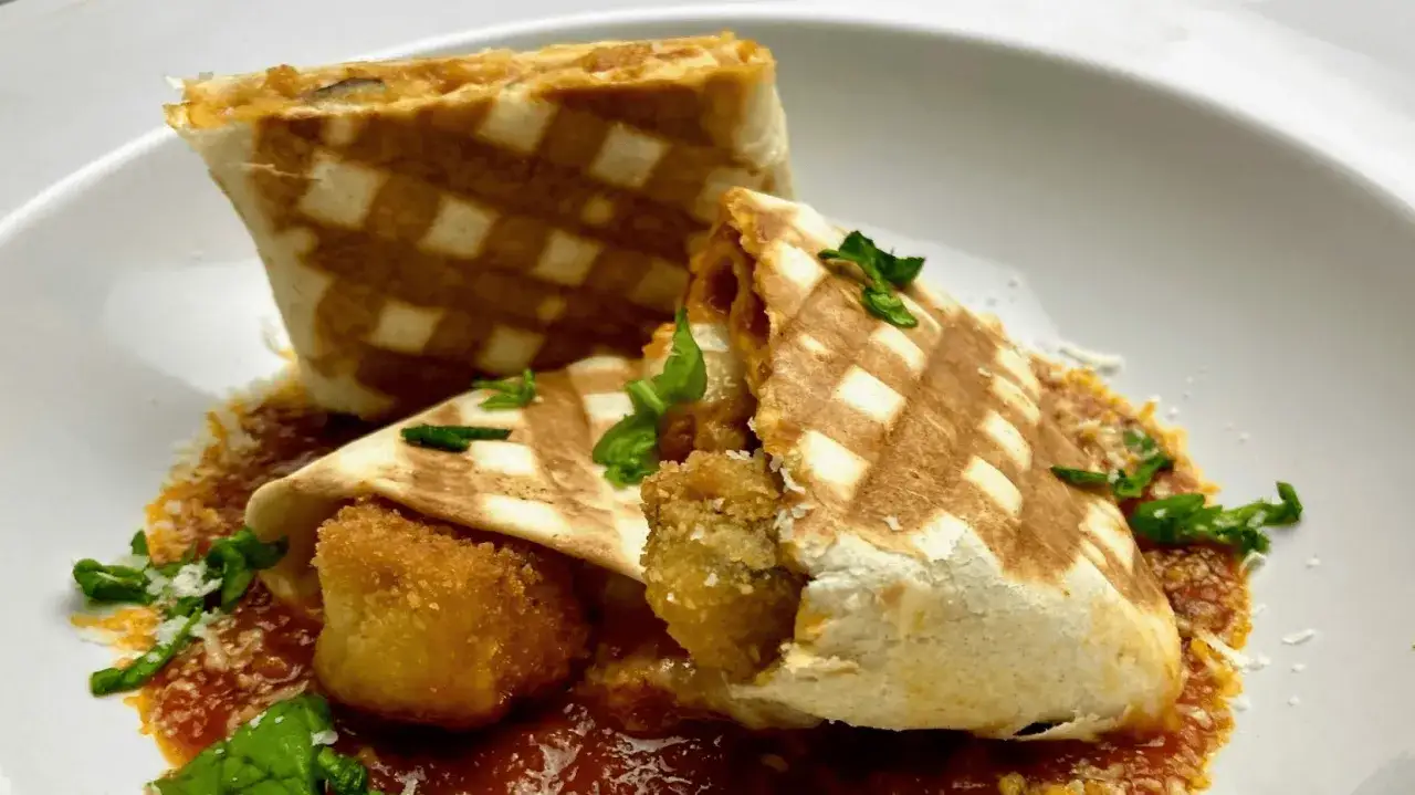 Gegrillte Piadina mit knusprigen Füllungen, serviert auf Tomatensauce mit Parmesan und Basilikum. Ein köstliches Piadina Rezept.