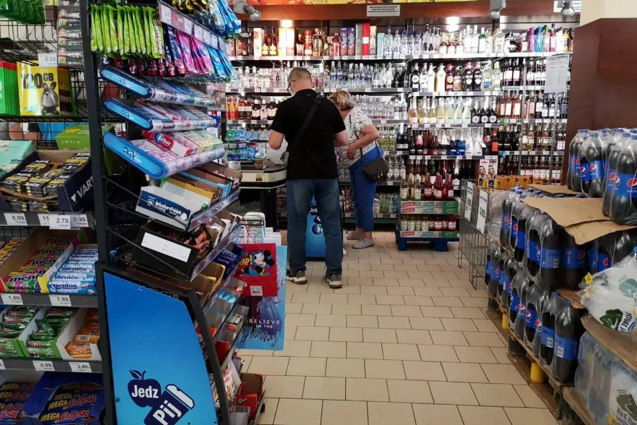 W sklepie w Czechach para wybiera słodycze i napoje. Na p&oacute;łkach widać gumy do żucia, batony i butelki Pepsi.