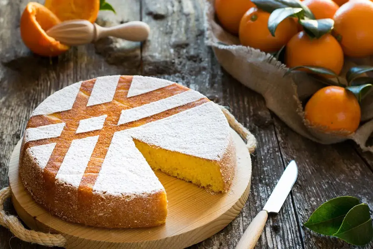 Torta soffice all'arancia, ricetta della nonna, con zucchero a velo e arance fresche.
