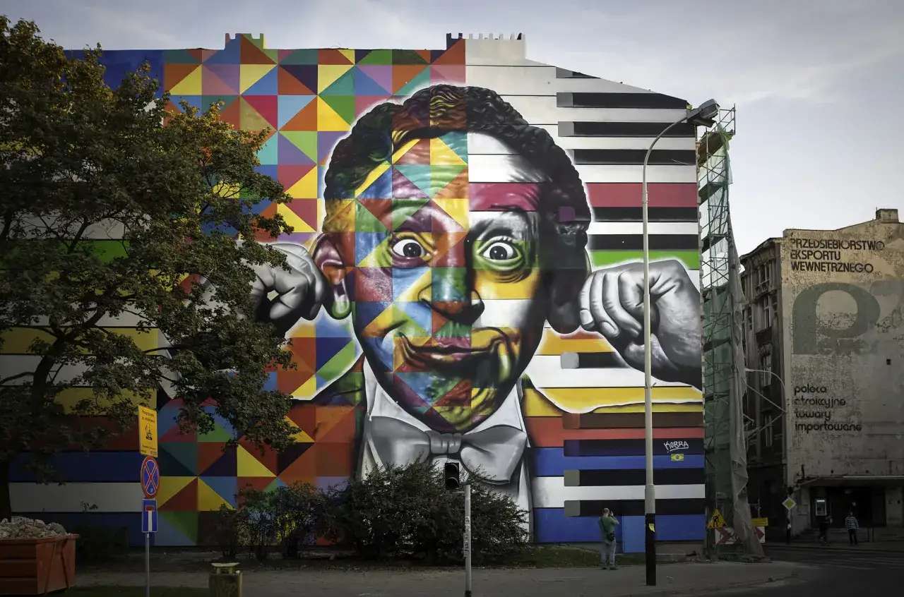 Vibrant mural of a man's face, split between colorful geometric patterns and grayscale piano keys, shows how graffiti has changed over time from simple tags to complex art.