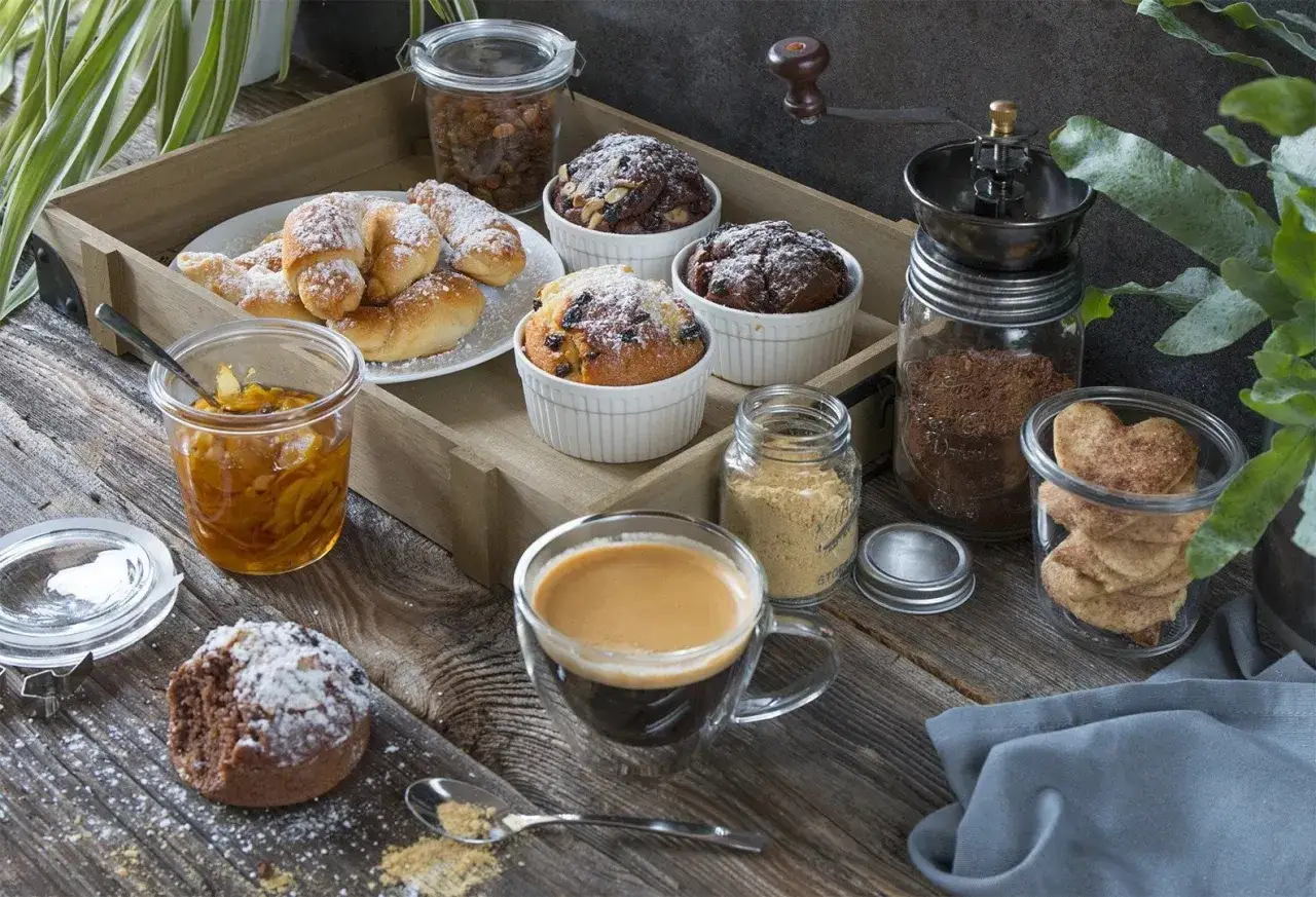Idealny moment na fika Szwecja: kawa, muffinki, rogaliki i ciasteczka w kształcie serc na drewnianej tacy.