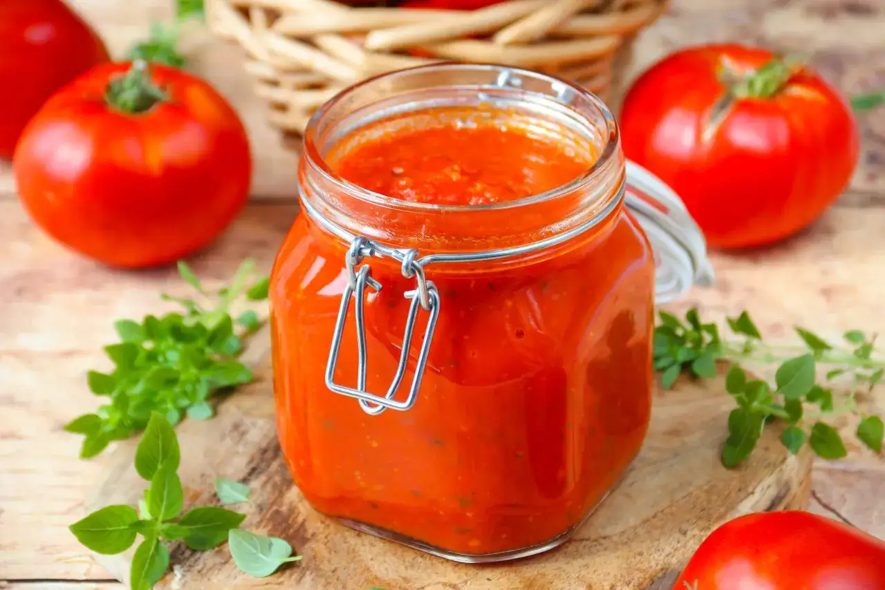 Un bocal de sauce tomate maison, avec des tomates fra&icirc;ches et du basilic. Parfait pour une recette facile et savoureuse.