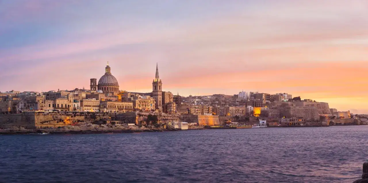 Valletta, Malta, im Dezember. Die Stadt erstrahlt im warmen Licht der untergehenden Sonne, w&auml;hrend das Meer ruhig vor der K&uuml;ste liegt. Ein malerischer Anblick, der das angenehme Malta Wetter im Dezember widerspiegelt.