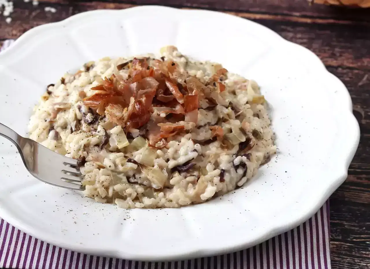 Krämig risotto med strimlad prosciutto och rödlök. Ett perfekt risotto recept för en mysig middag.