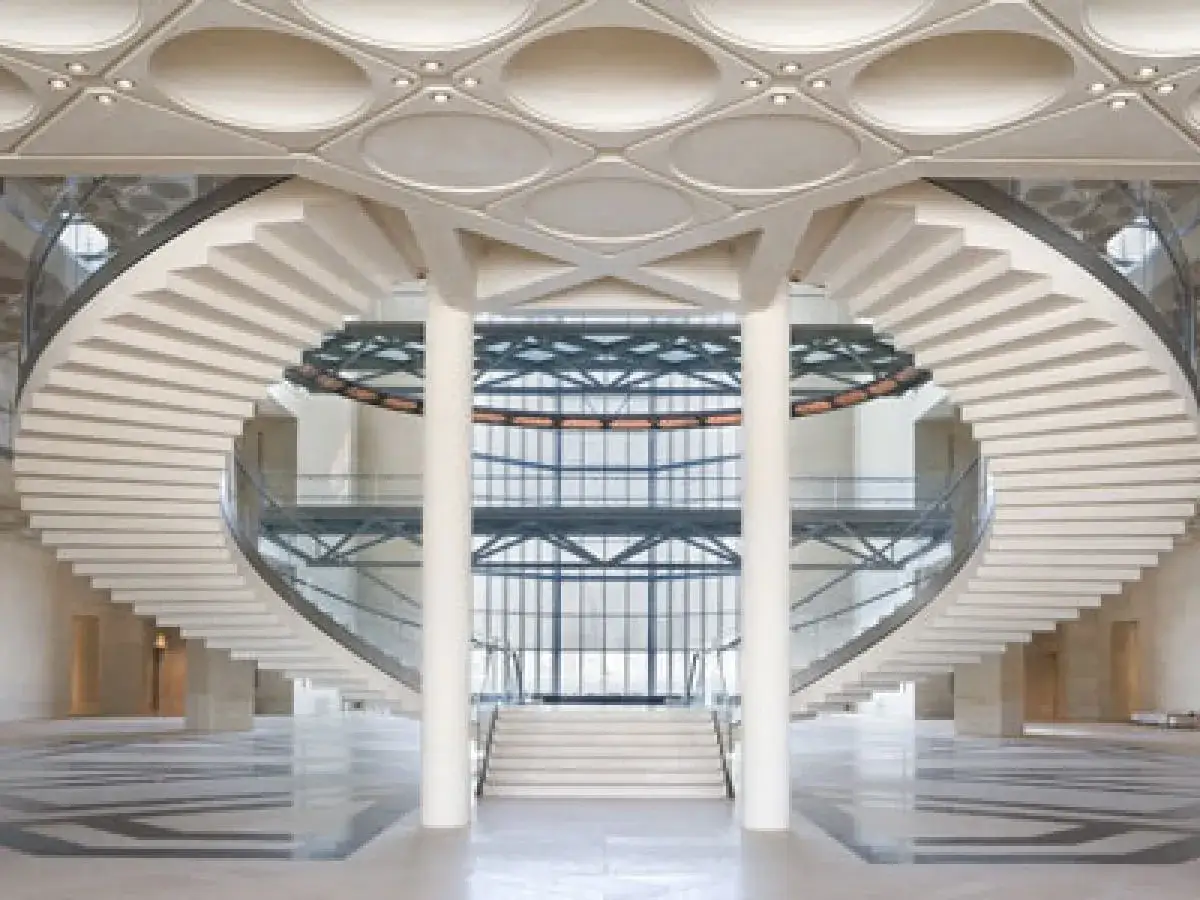 Wielkie, spiralne schody w muzeum sztuki islamskiej, prowadzące do przeszklonego atrium.