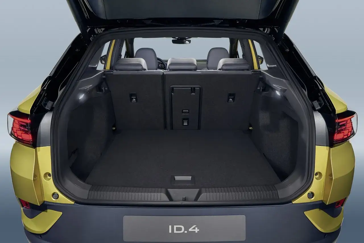 Vue du coffre ouvert d'une Volkswagen ID.4 jaune. Le volume du coffre est spacieux, prêt à accueillir vos bagages pour un long voyage.