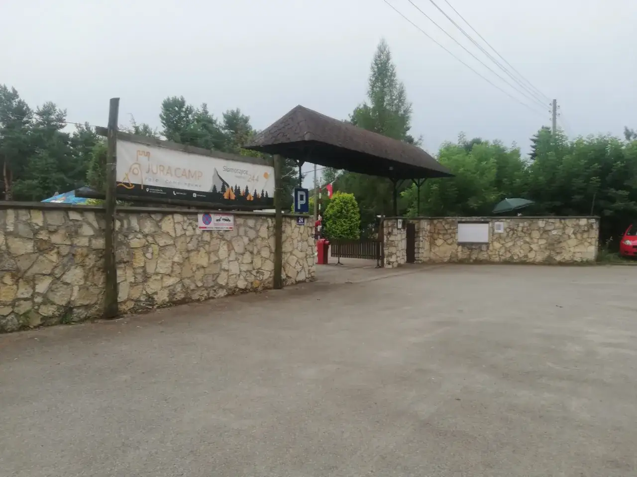 Wjazd na siamoszyce camping. Kamienny mur, baner 