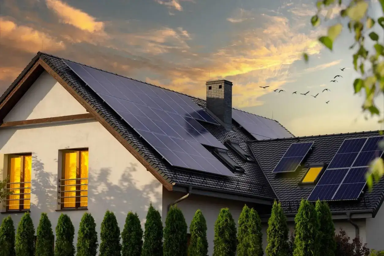 Maison avec panneaux solaires sur le toit, promesse de **panneau solaire rentabilit&eacute;** et d'un avenir plus vert. Le ciel au coucher du soleil est magnifique.