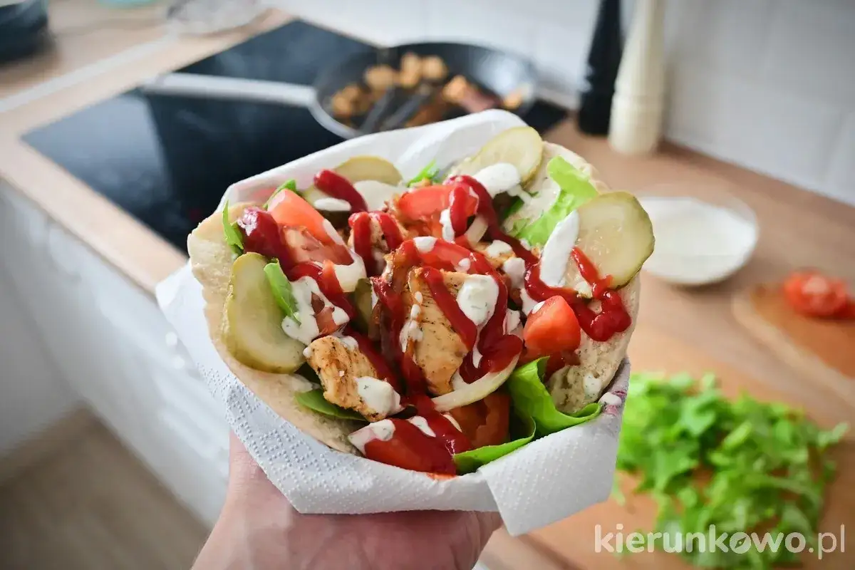 Pyszna shoarma drobiowa w picie z pomidorami, ogórkiem i sałatą, polana sosem. Idealna na szybki obiad.