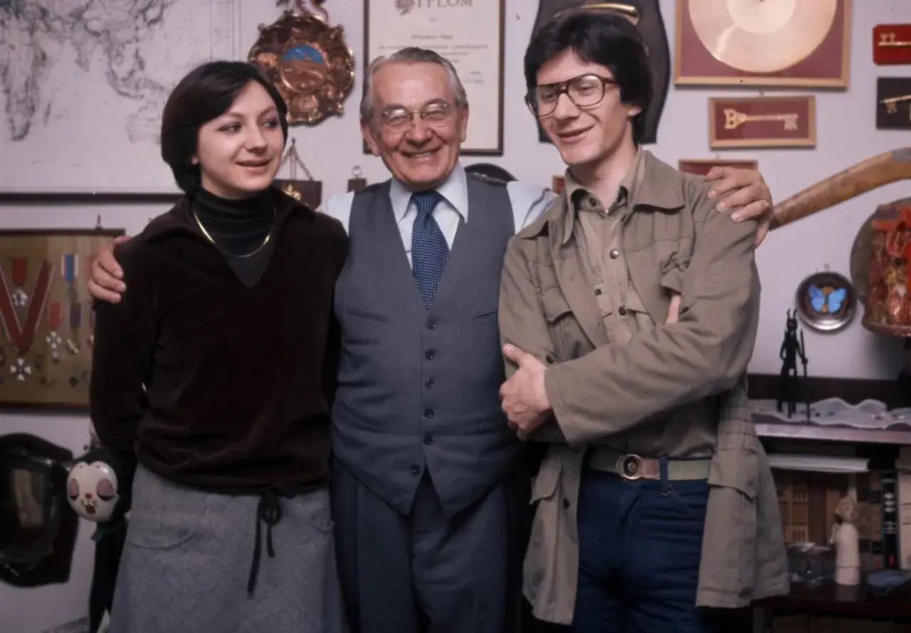 Mieczysław Fogg i jego rodzina. Dwoje młodych ludzi stoi obok starszego mężczyzny, tworząc obraz jego podwójnego życia.