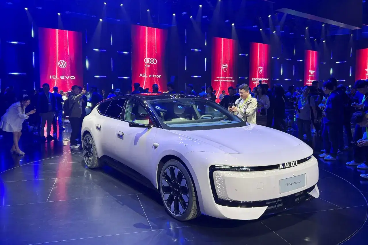 Auto elettriche cinesi in mostra, con un modello bianco Audi E5 Sportback in primo piano.