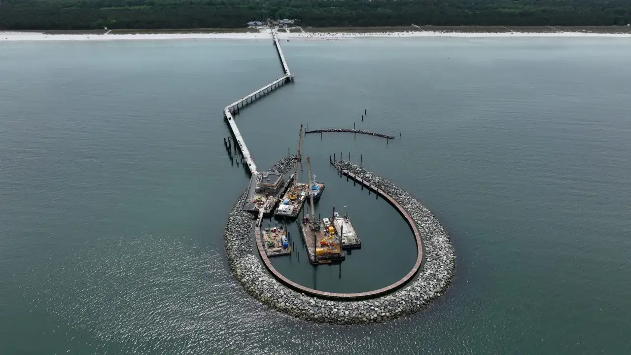 Der Prerow Hafen mit seiner markanten, hufeisenförmigen Mole, auf der Boote und Kräne liegen.