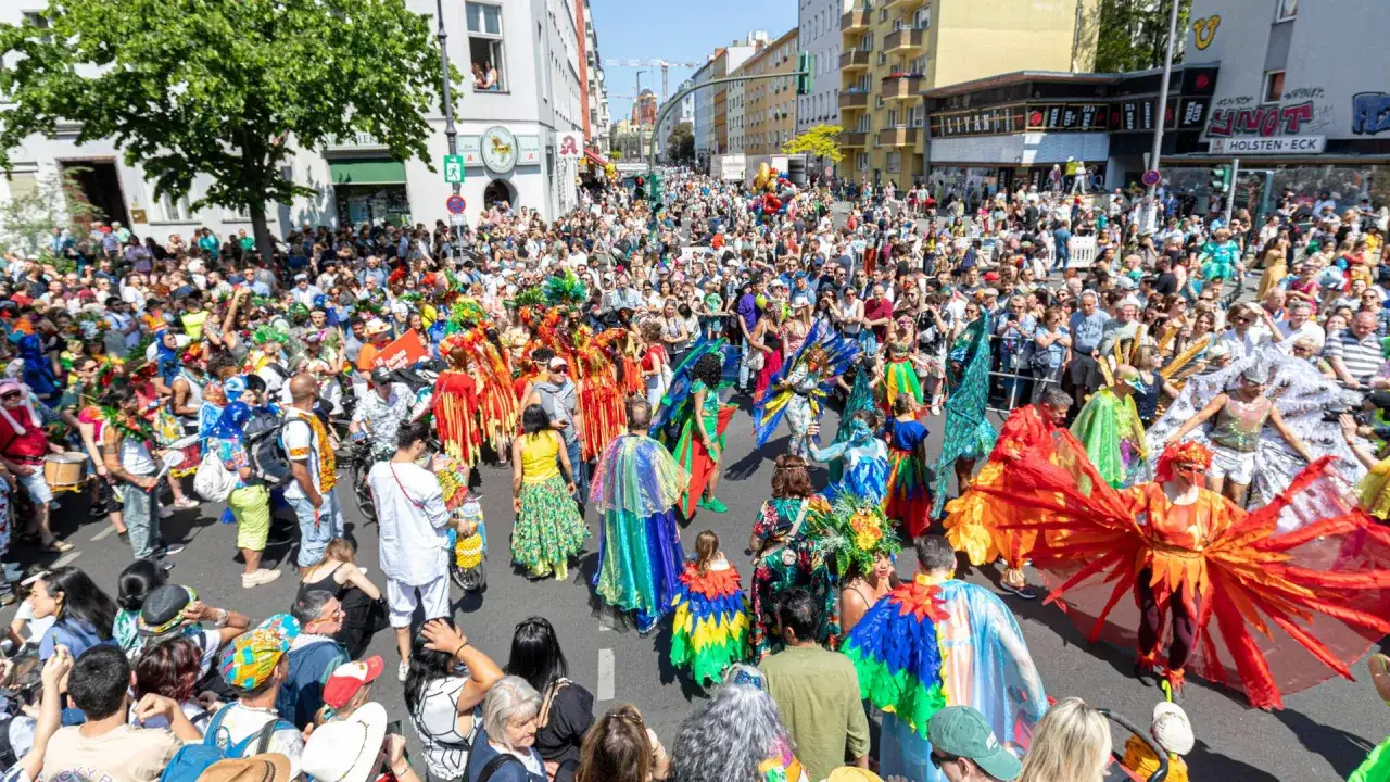 Bunte Kost&uuml;me und fr&ouml;hliche Menschen beim Carnival of Cultures Berlin. Eine lebendige Parade feiert Vielfalt auf den Stra&szlig;en.